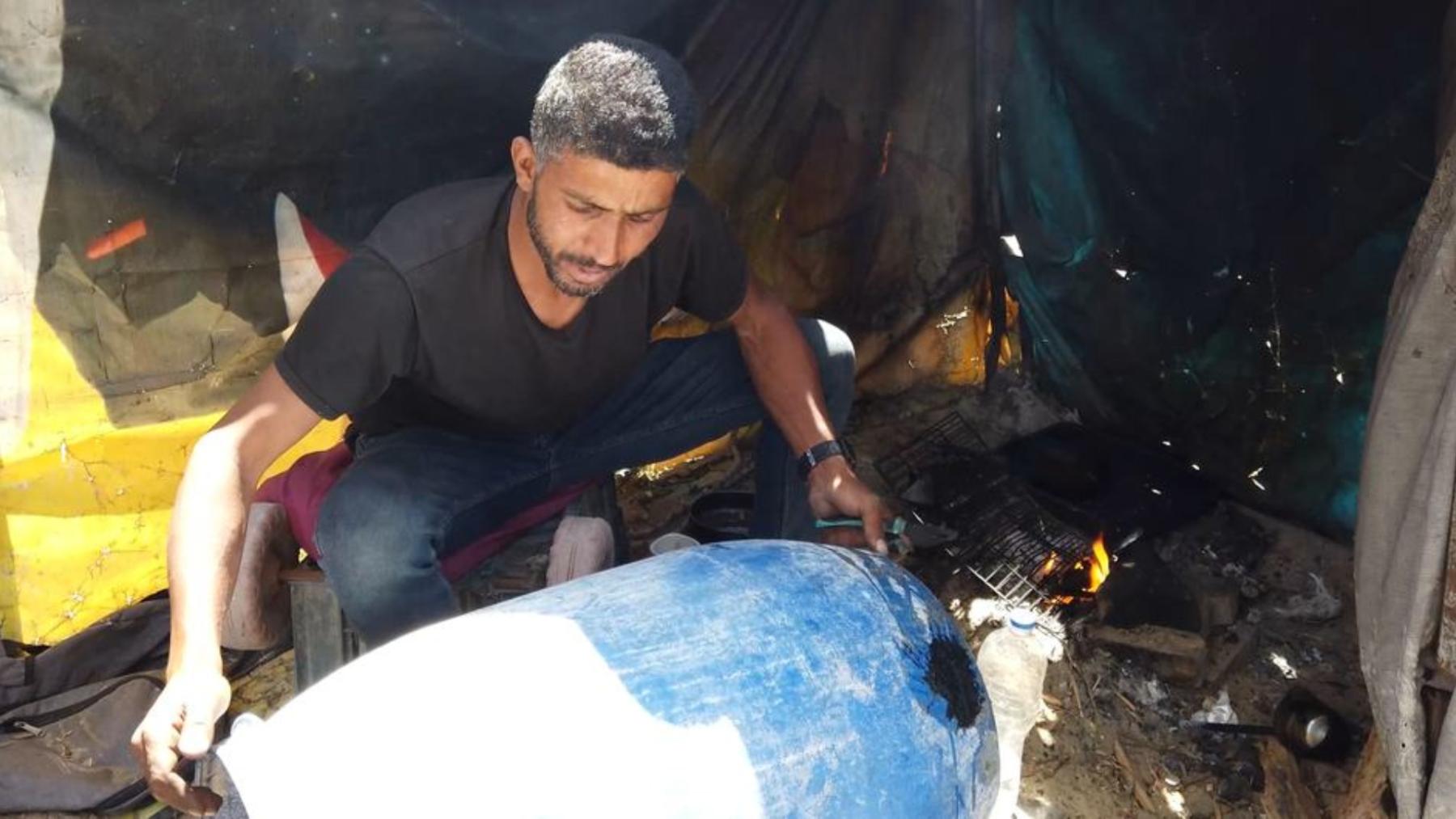 Moamen Abu Asr arreglando un tanque de agua.