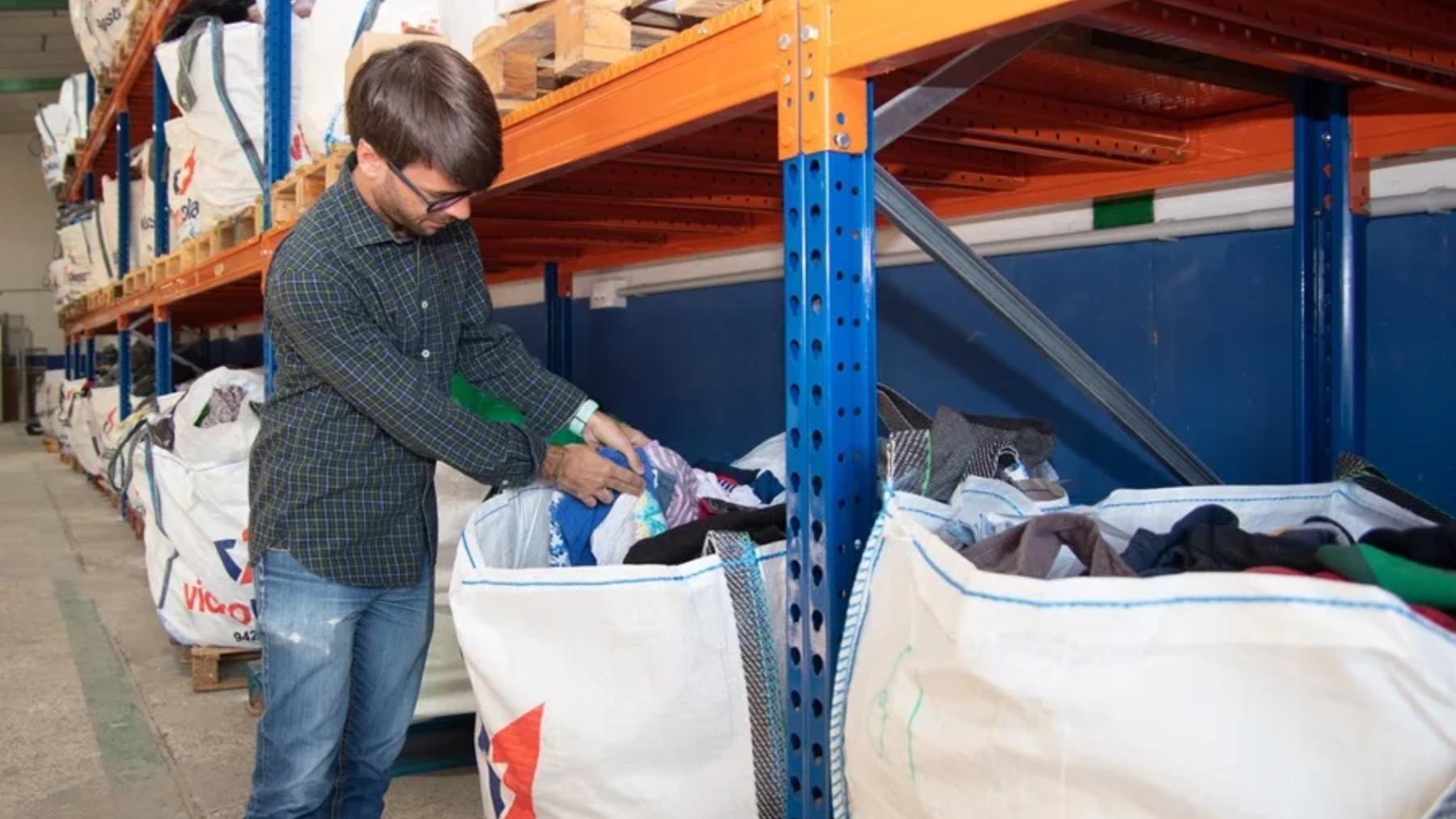 Una persona inspecciona el contenido de grandes bolsas con residuos, en una imagen de archivo.