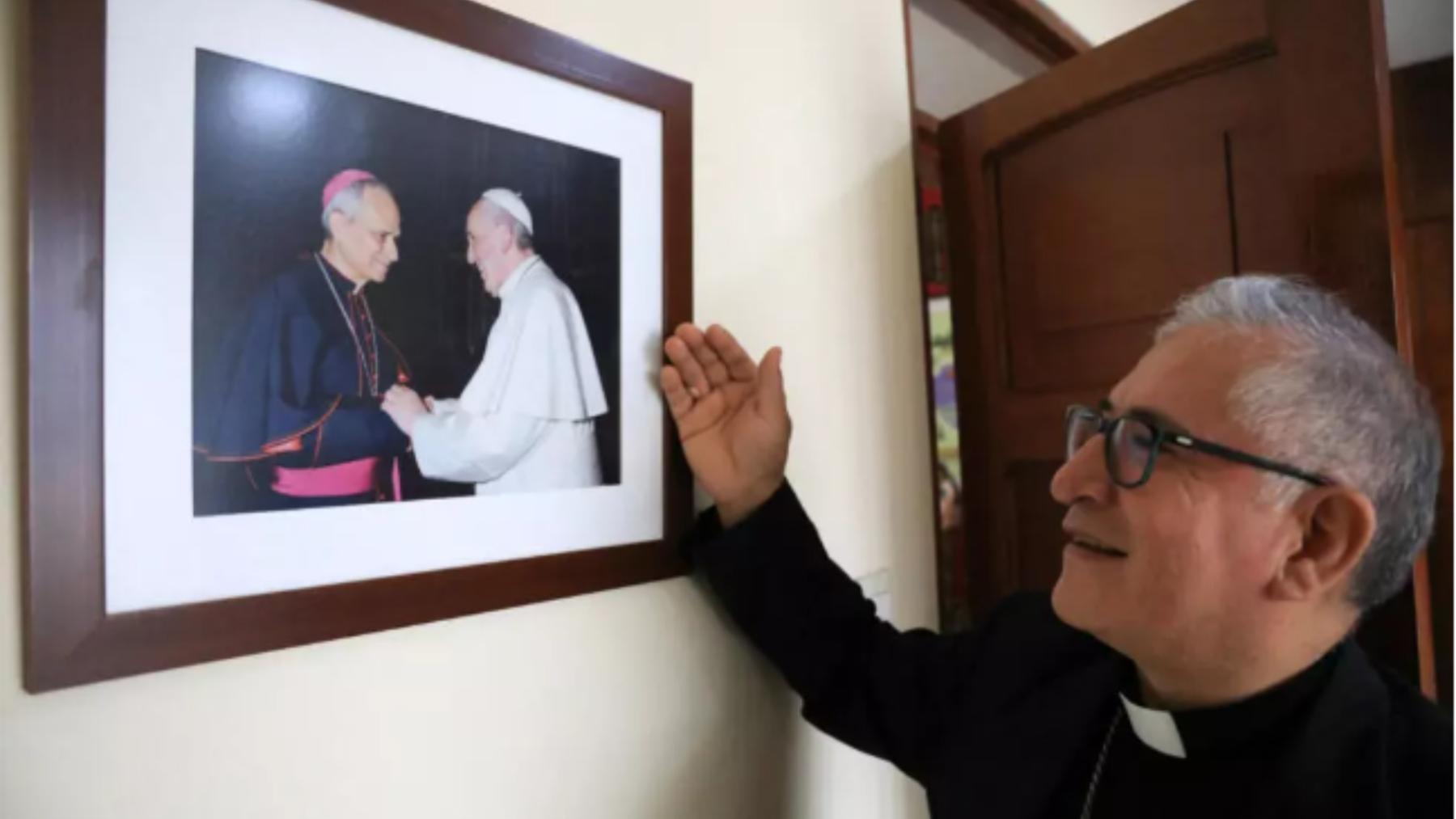Monseñor Luis Alberto Barrera, actual obispo del Callao, muestra una foto de Robert Francis Prevost con el papa Francisco en la Diócesis del Callao, de la cual Prevost fue Administrador Apostólico entre 2020 y 2023, en Callao, Perú, el 8 de mayo de 2025. 